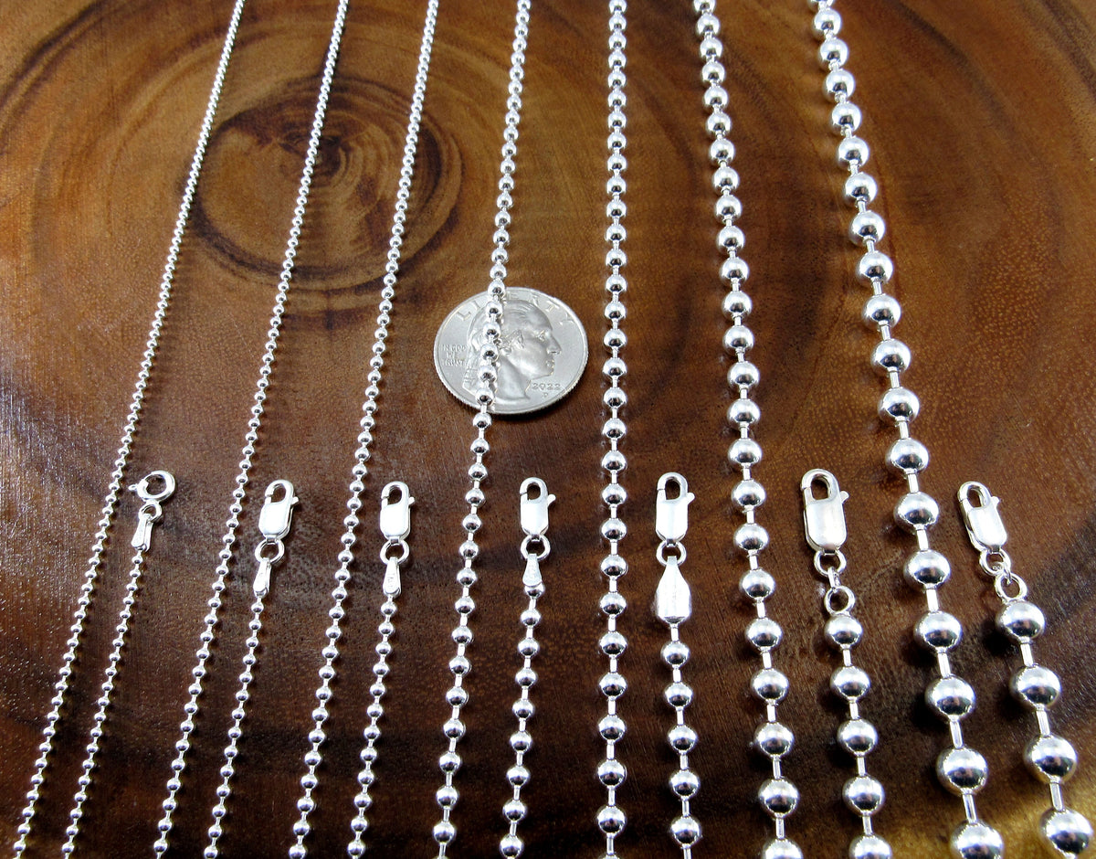 The solid sterling silver bead chains feature silver wire with round balls threaded on it to form a chain. Each chain closes with a lobster claw clasp. Many widths and lengths are available from 1.5mm to 6mm wide and 7 to 36 inches long.